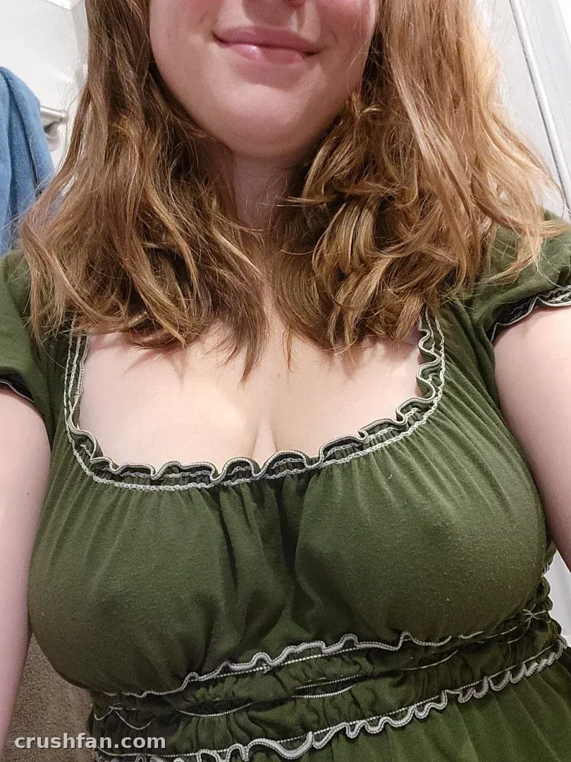 AwesomeKate dans un haut vert à volants avec des cheveux ondulés dans un selfie rapproché
