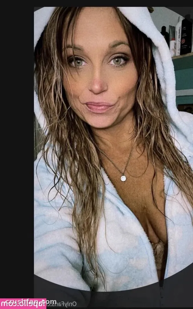 Abbey Lane in a light blue hooded robe, looking at the camera in a close-up selfie.
