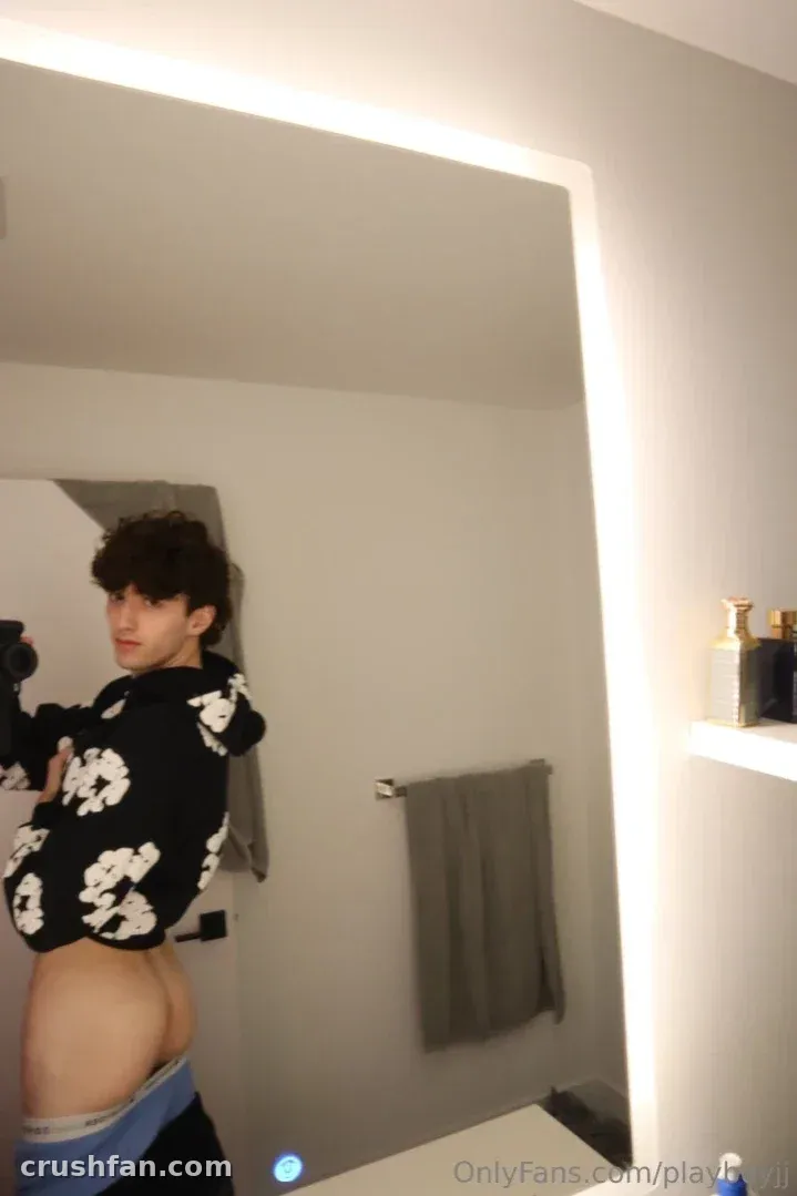 Jayden in a floral black top taking a mirror selfie in a bright bathroom