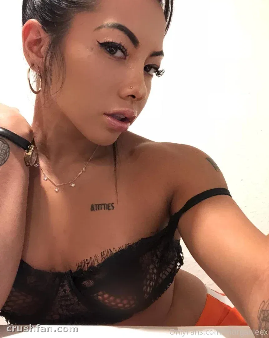 Close-up selfie of Lilkymchii in a black lace top against a white background