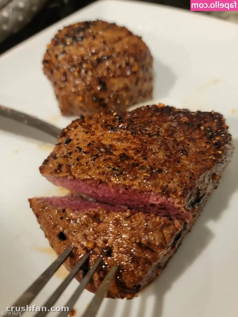 Close de bife selado fatiado em um prato branco com um garfo