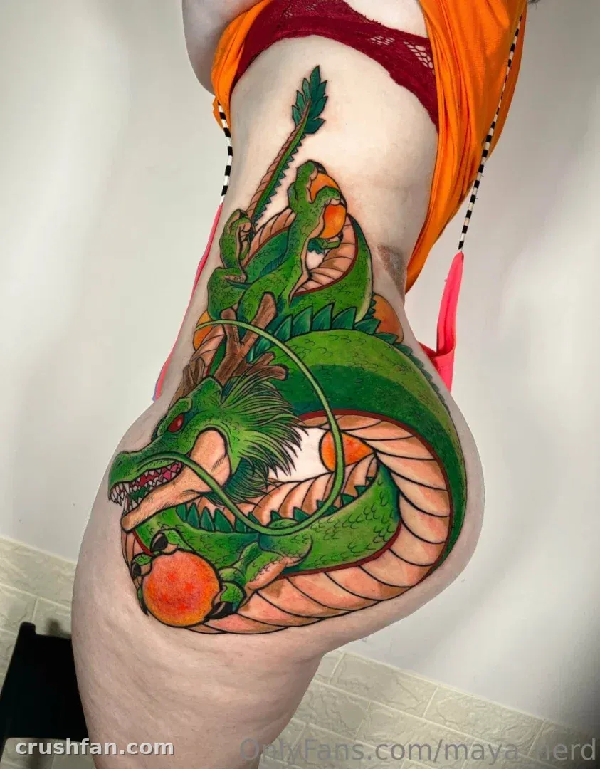 Maya exibe uma grande tatuagem de dragão verde em sua perna em uma selfie no espelho.