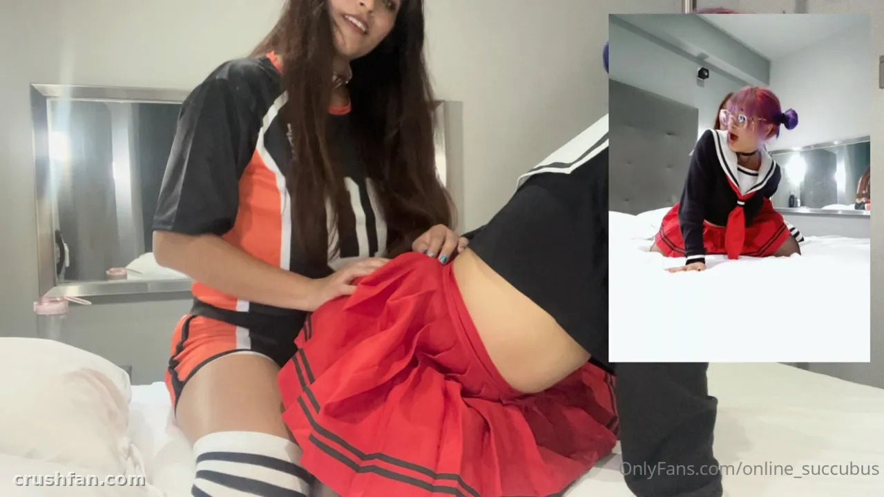 Creator dans une tenue de sport rouge et noire assise sur un lit blanc près d'un miroir
