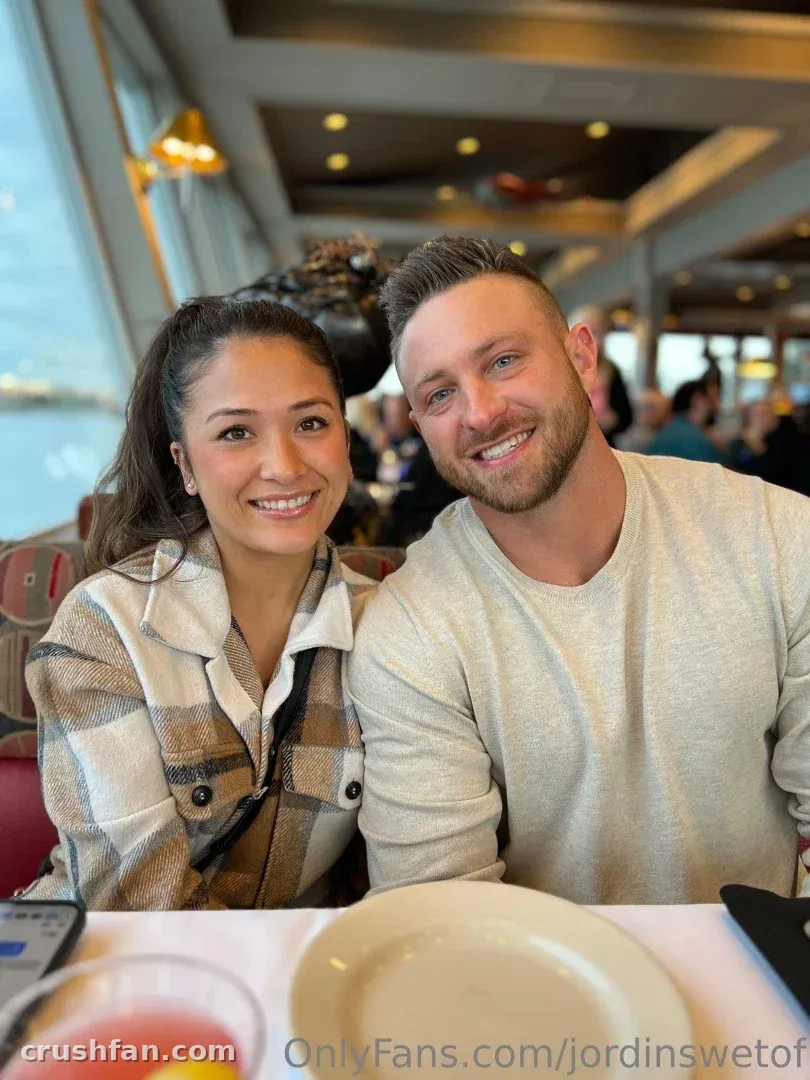 Jordinswetof smiling in a plaid shirt at a restaurant table with a companion.