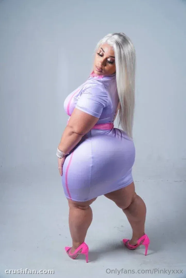 Creator in a lilac dress and pink heels posing in a studio