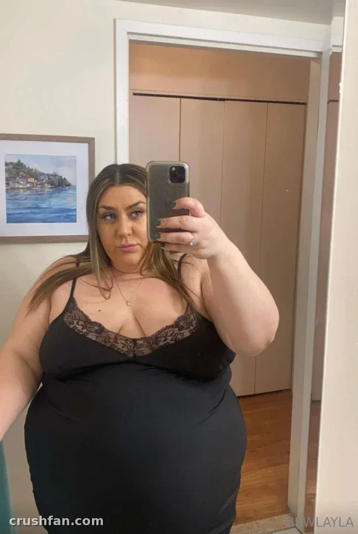 BBW Layla in a black lace-trim top taking a mirror selfie indoors