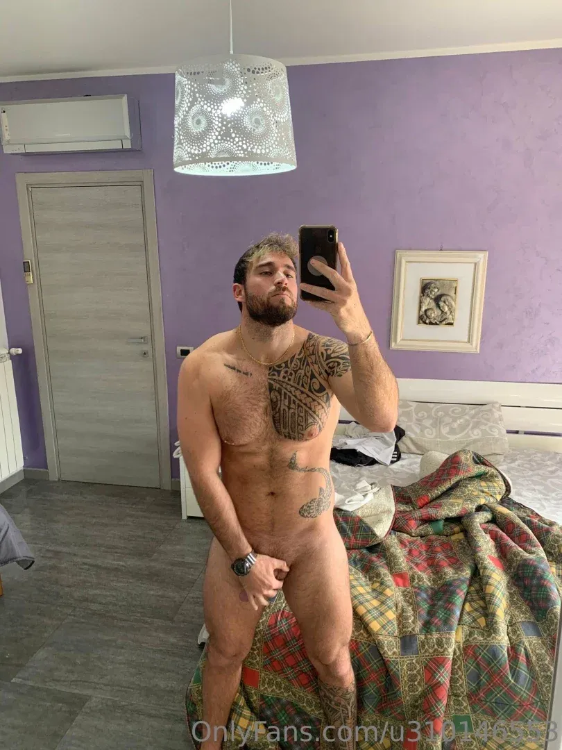 Drake tirando uma selfie no espelho em um quarto roxo com um cobertor estampado na cama