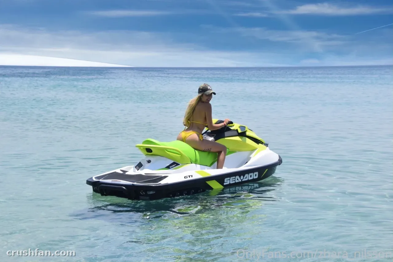 Zhara Nilsson in a yellow bikini riding a jet ski on clear blue water