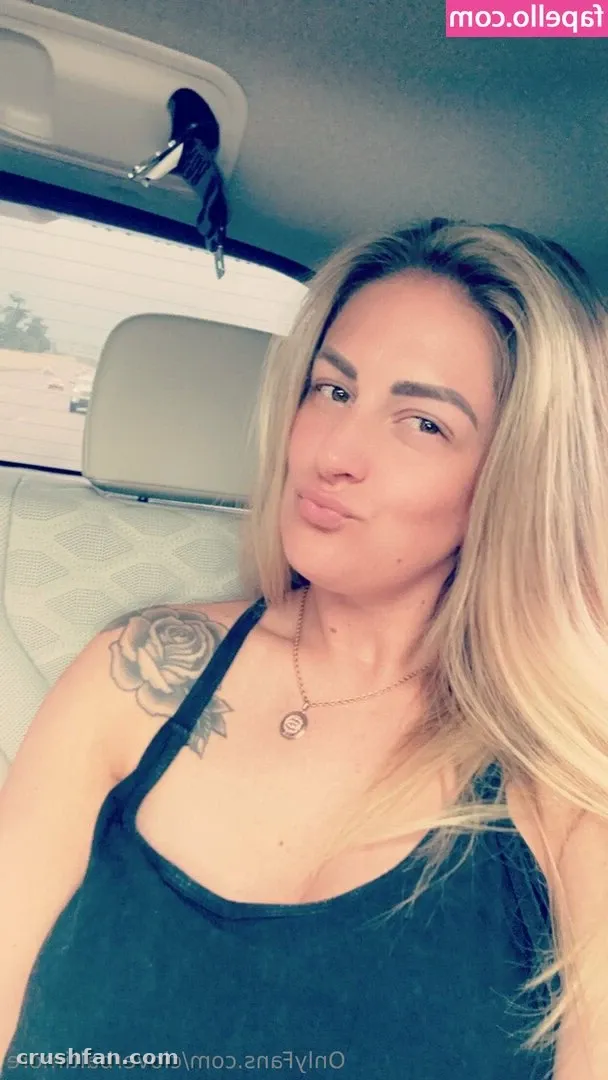 Cloverbaltimore smiling softly in a car selfie wearing a dark top.
