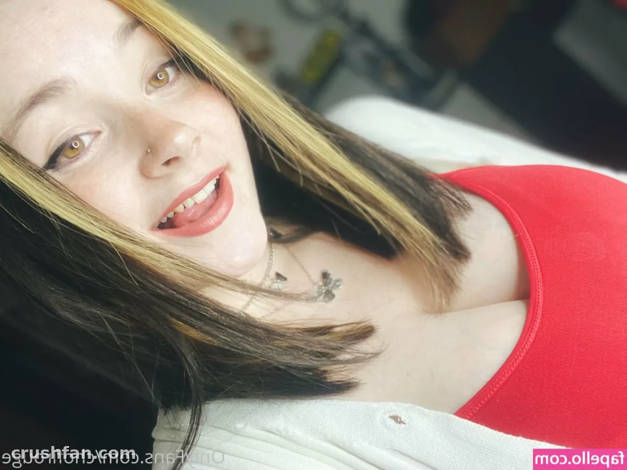 Selfie de primer plano de Chofi sonriendo, con un top rojo y una chaqueta clara, y cabello con mechas rubias.