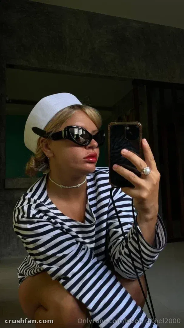 Lovely❤️Rachel de blusa listrada e boné branco tirando uma selfie no espelho em ambiente interno