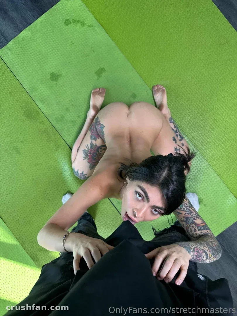 The Stretch Master Show with tattoos on a green mat in a studio, viewed from above.
