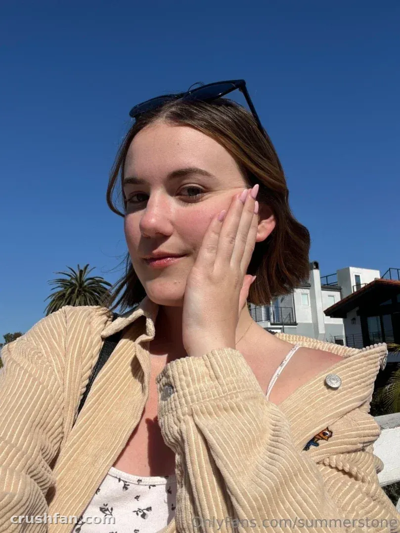 Summer in einer beigen Cordjacke im Freien unter klarem blauem Himmel