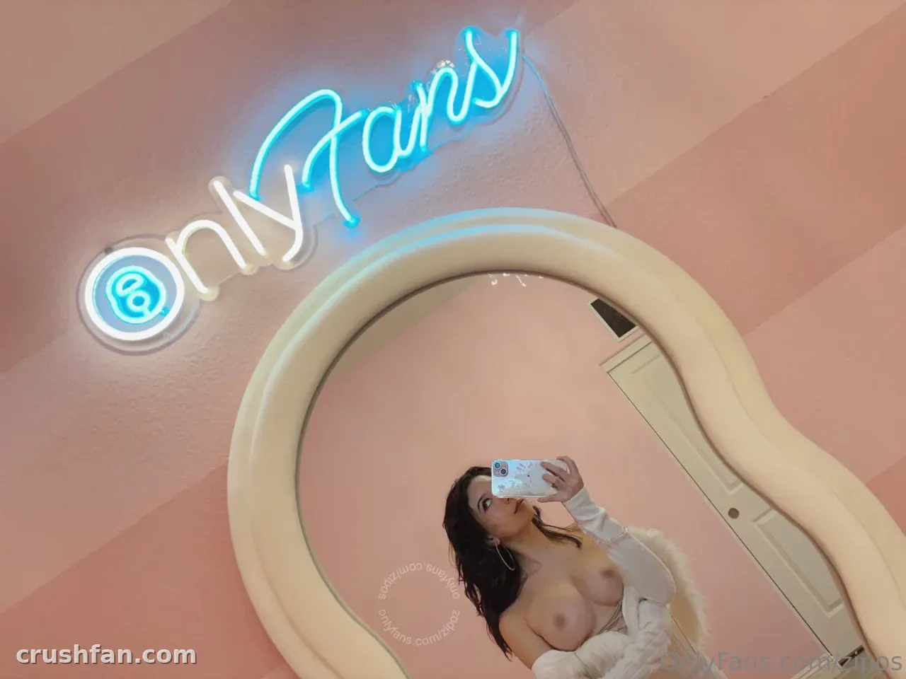 Alyssa takes a mirror selfie in a pink room with a blue neon sign above her.