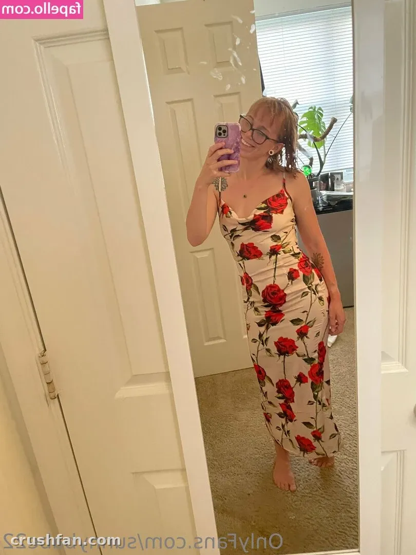 Sweet Sunny in a white dress with red roses taking a mirror selfie indoors