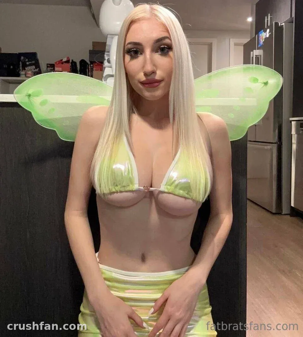 Fatbrat in a green fairy costume with wings posing in a kitchen