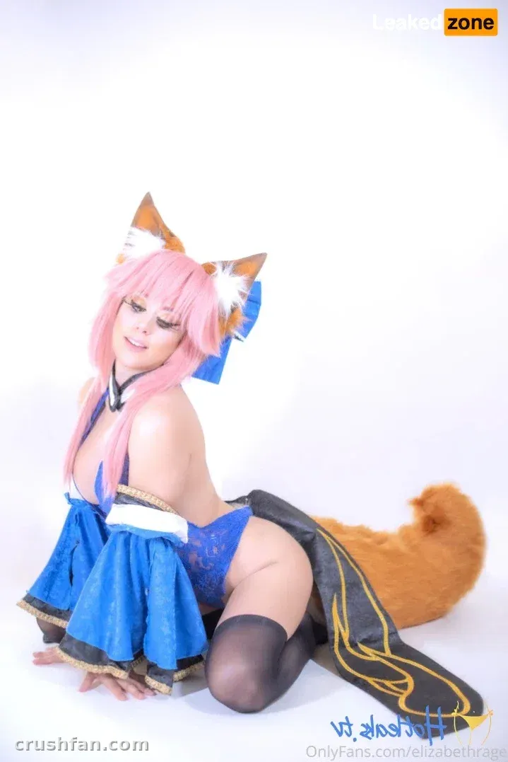 Cosplayer in a pink wig and blue costume with animal ears posing on a white studio background