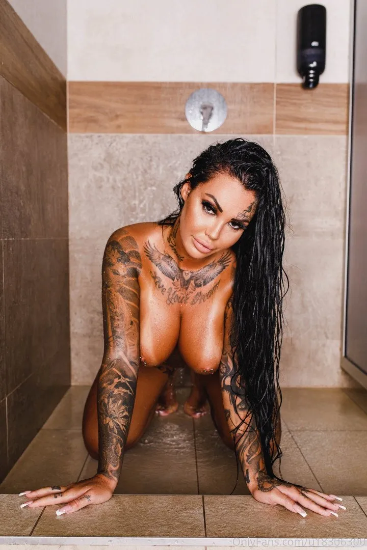 Andjela Vestica VIP de rodillas en una ducha alicatada con cabello mojado y tatuajes