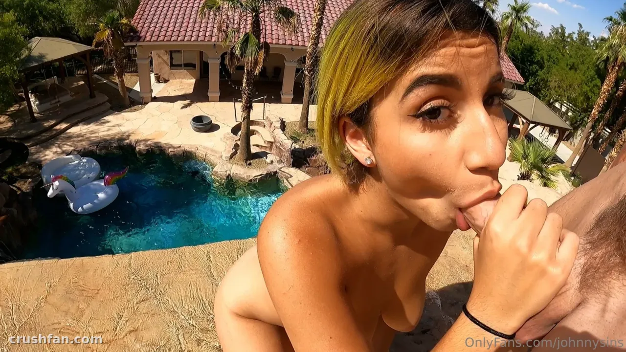 Creator neben einem türkisfarbenen Pool auf einer sonnigen Terrasse mit Palmen und einer weißen Schwimminsel