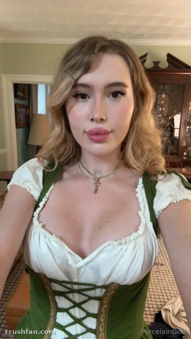 Rosealine in einem Outfit im grün-weißen Dirndl-Stil drinnen