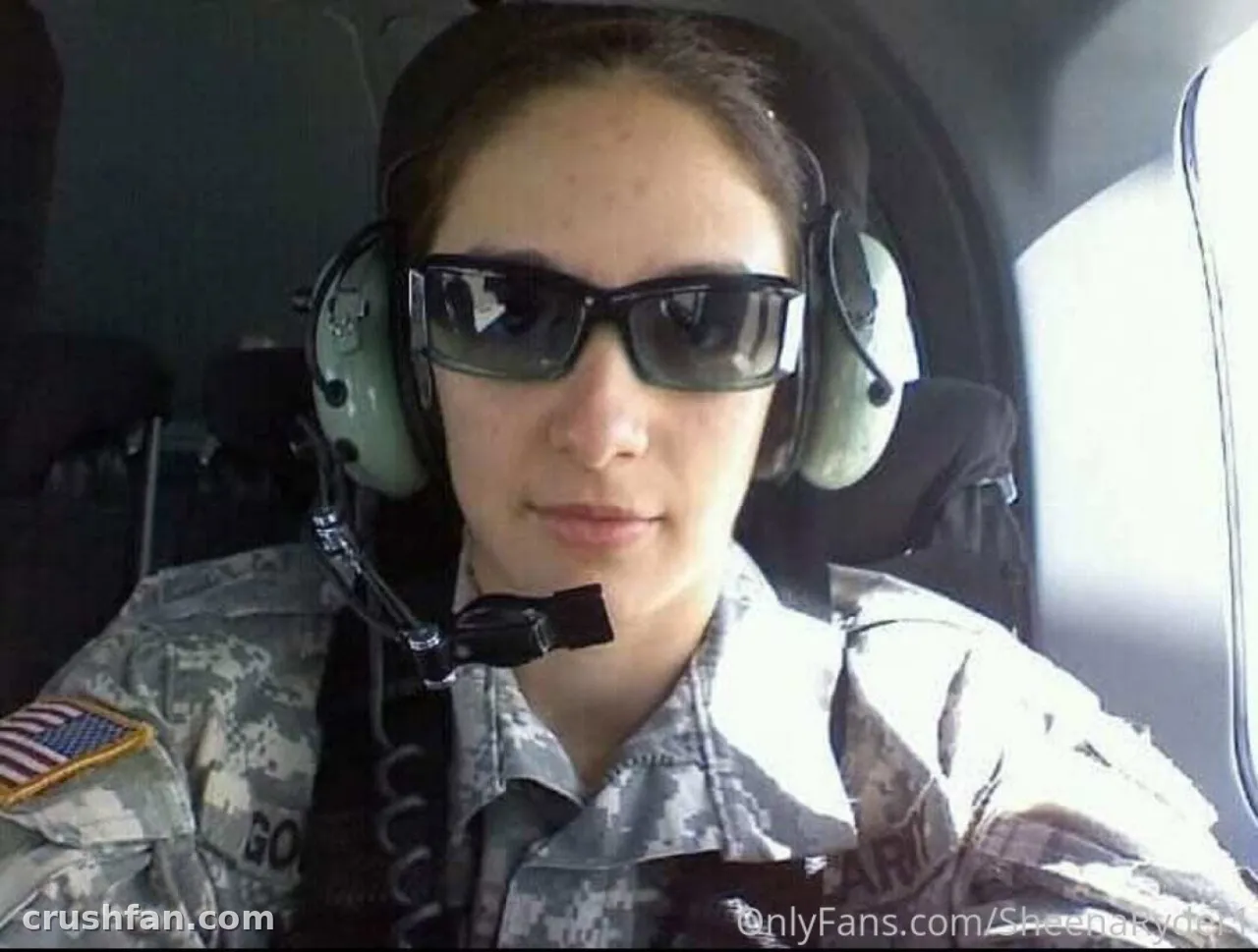 Criador em uniforme de camuflagem e headset usando óculos escuros dentro de um cockpit
