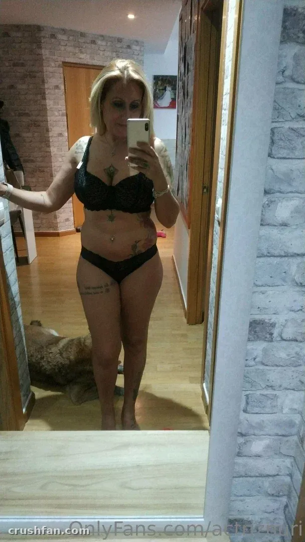 Actriz Nuria taking a mirror selfie in black lingerie in a hallway