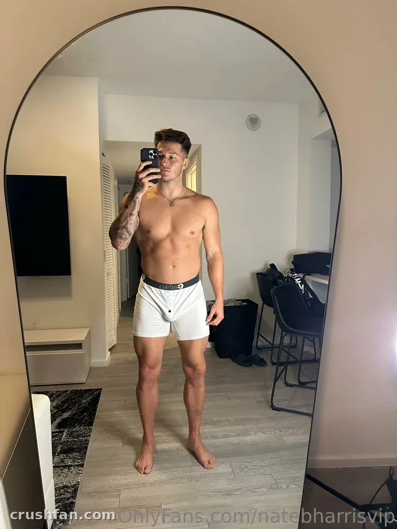 Nate taking a shirtless mirror selfie in white boxer briefs indoors