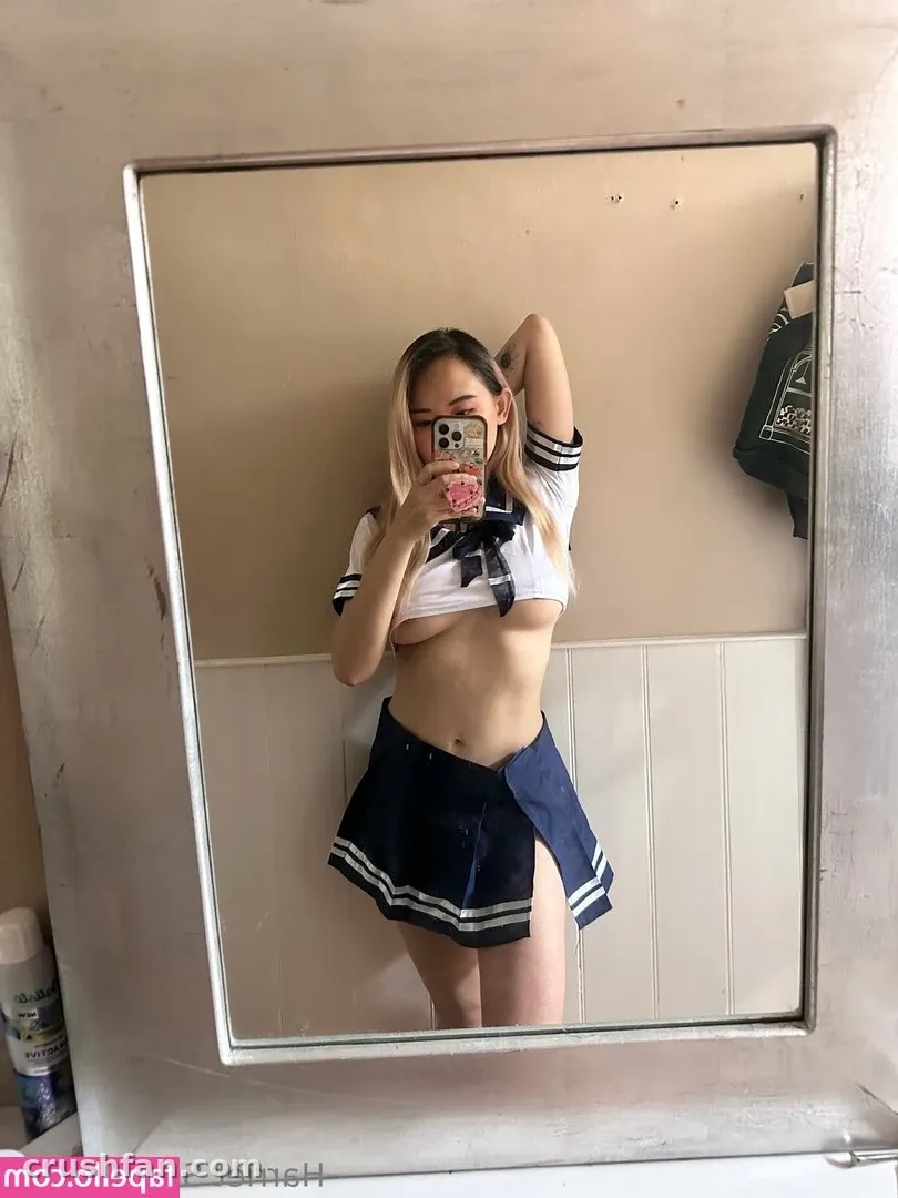 Creator in a navy and white sailor-style outfit taking a mirror selfie in a bright room