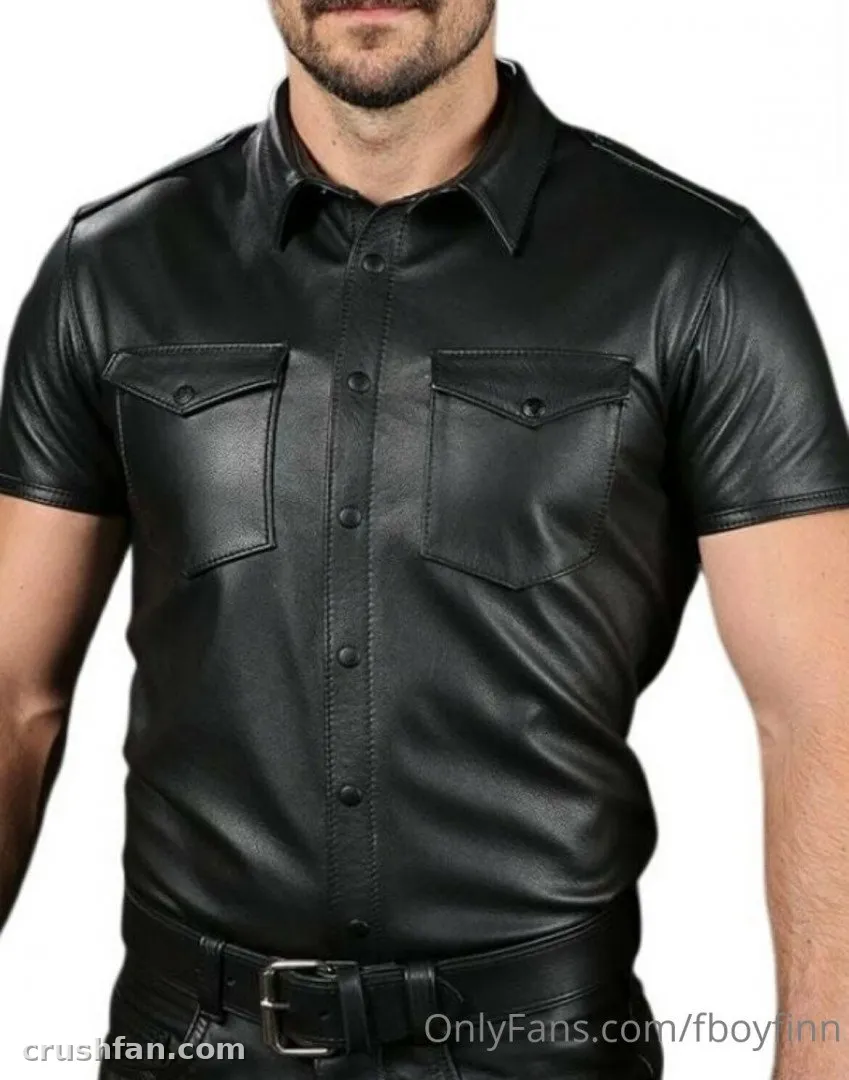 Creator in a black leather short-sleeve shirt and belt against a white studio background