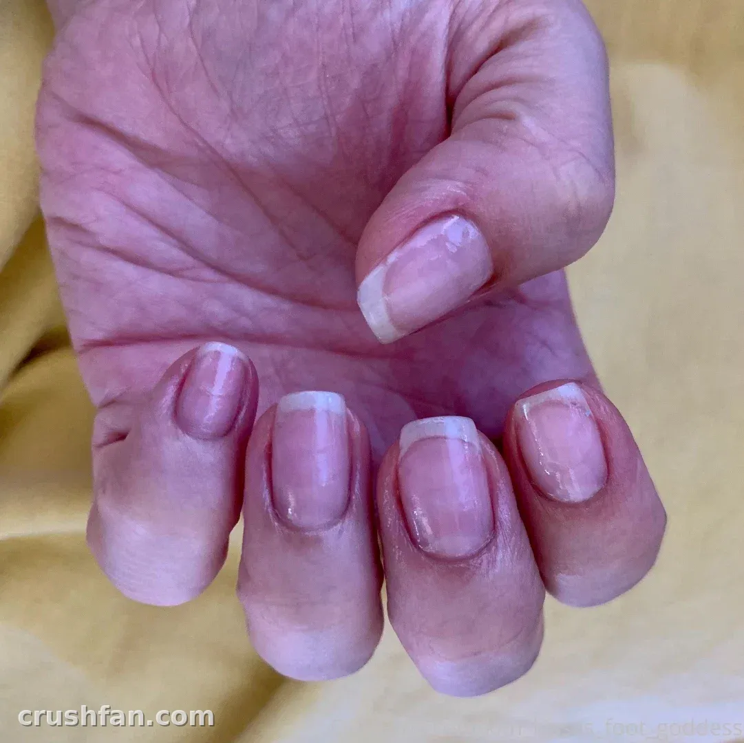 Close-up of a manicured hand resting on soft fabric