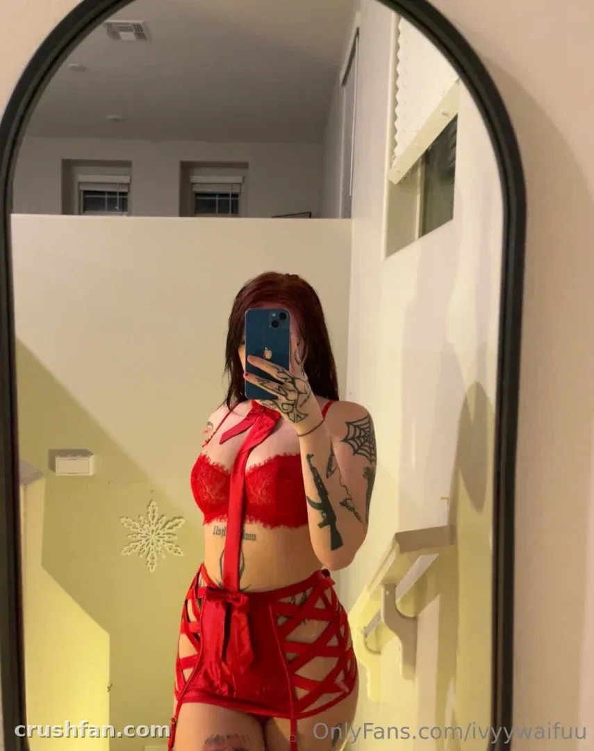 Ivy in a red two-piece outfit taking a mirror selfie indoors