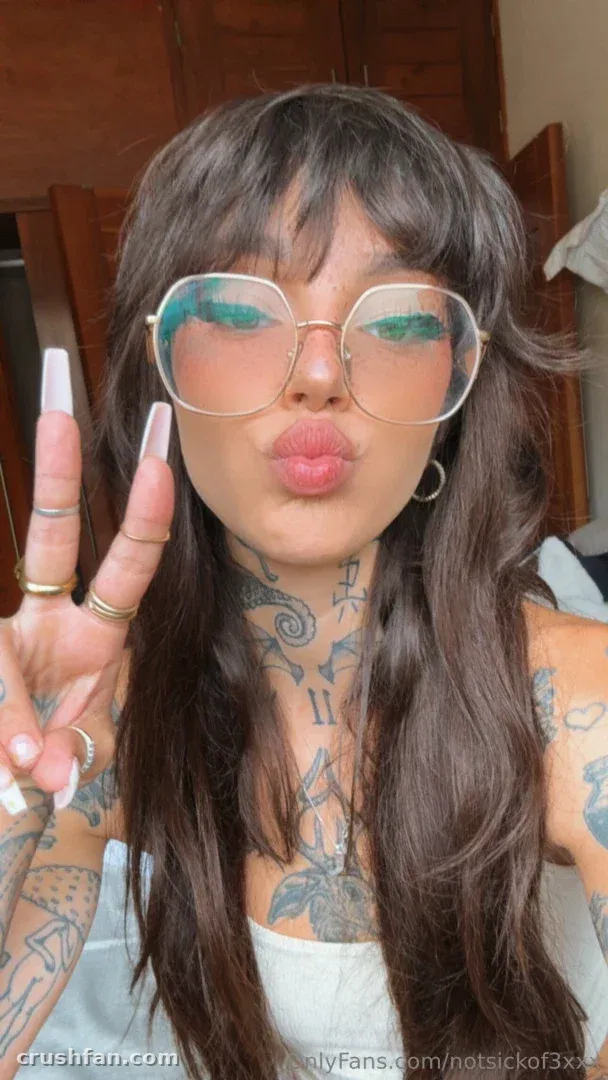 Keaton Belle con gafas tintadas haciendo el signo de la paz en interiores