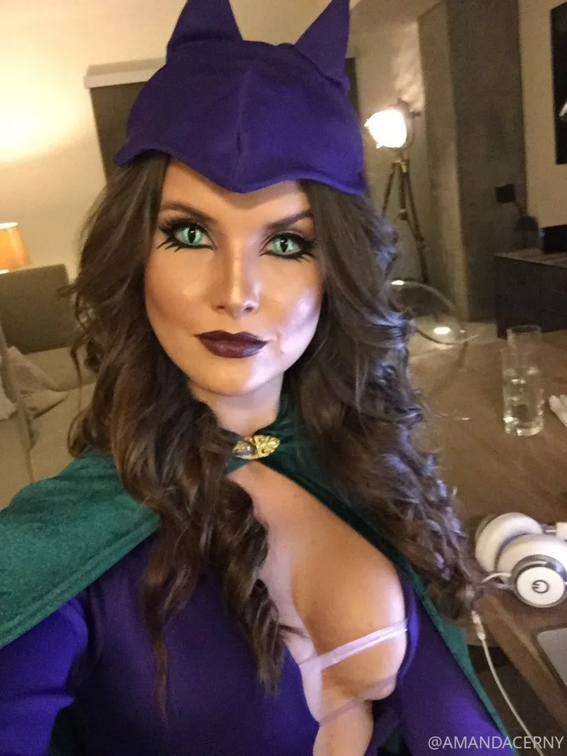 Amanda Cerny in a purple cat-eared costume and green cape indoors