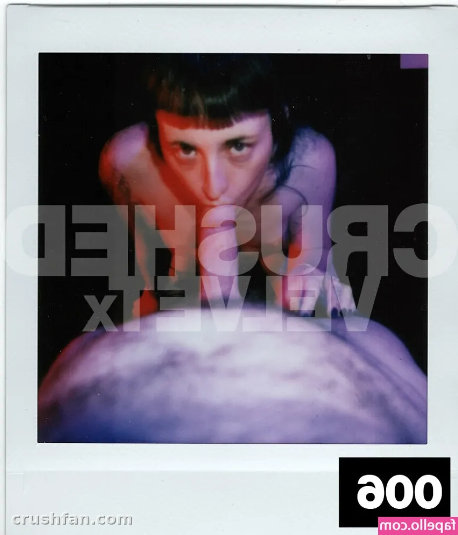 Close low-angle portrait of a creator against a dark background with violet light