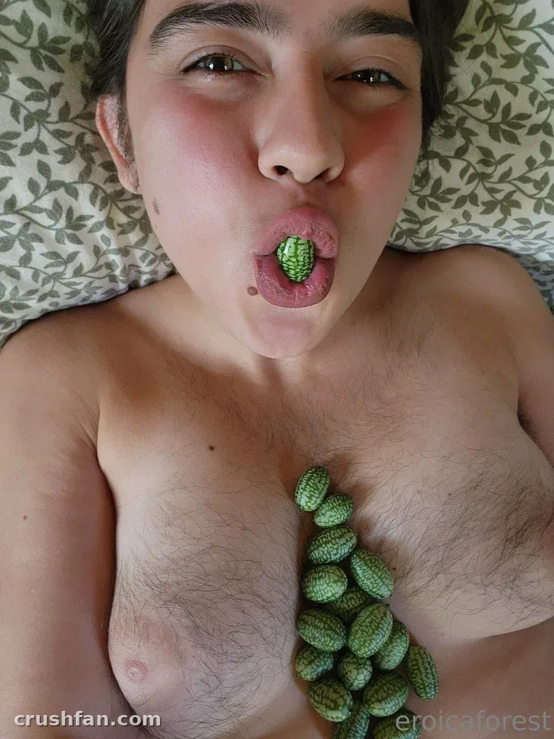 Creator deitada sobre roupa de cama estampada com frutas verdes dispostas no peito