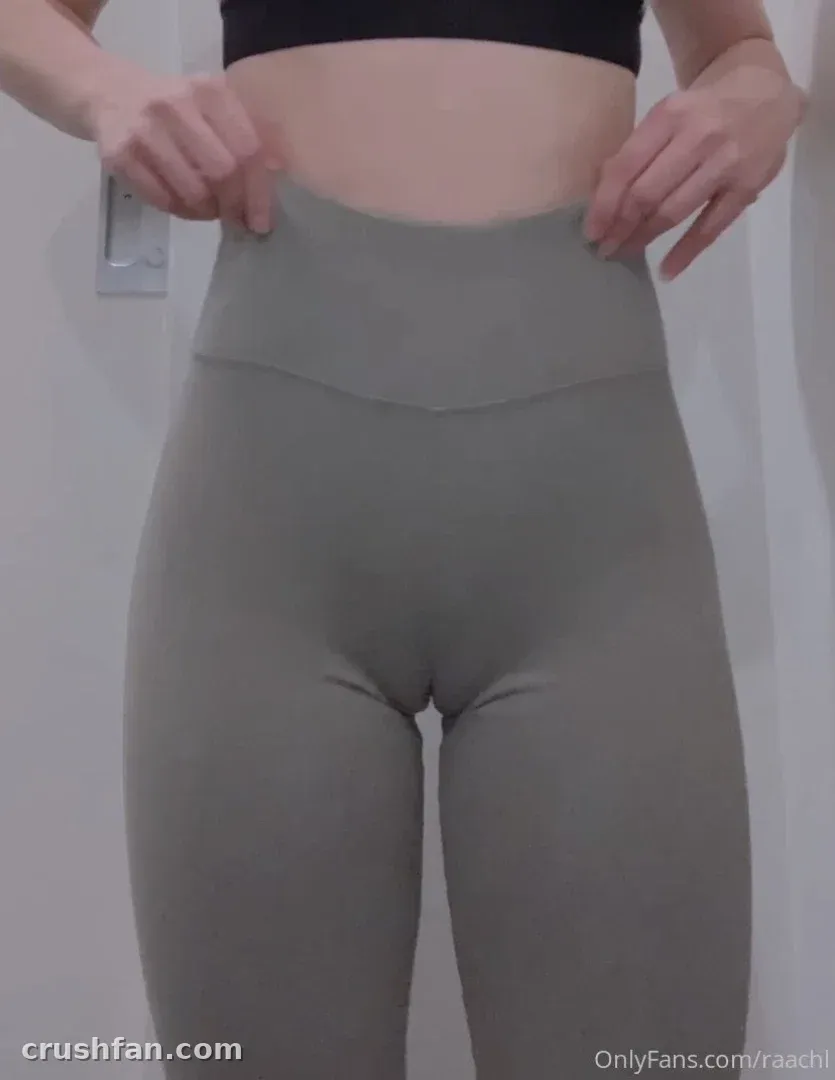 Rachel in a black crop top and grey high-waisted leggings, hands at the waistband