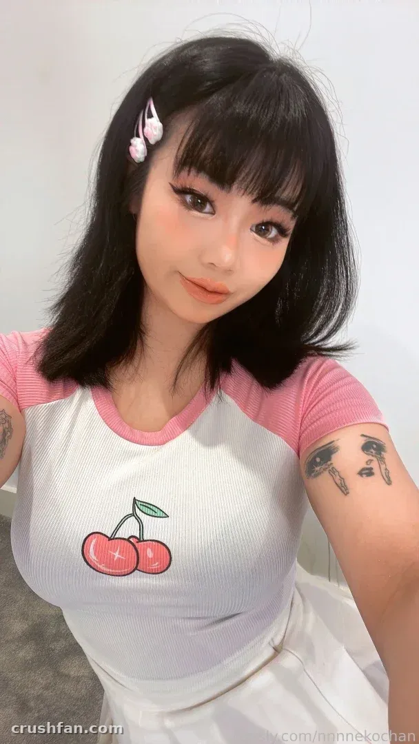 nnnnekochan taking a selfie in a pink and white cherry print top indoors.