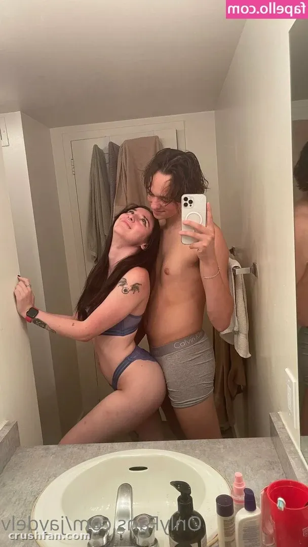 Jayde in a dark grey two-piece set posing for a bathroom mirror selfie with a companion.