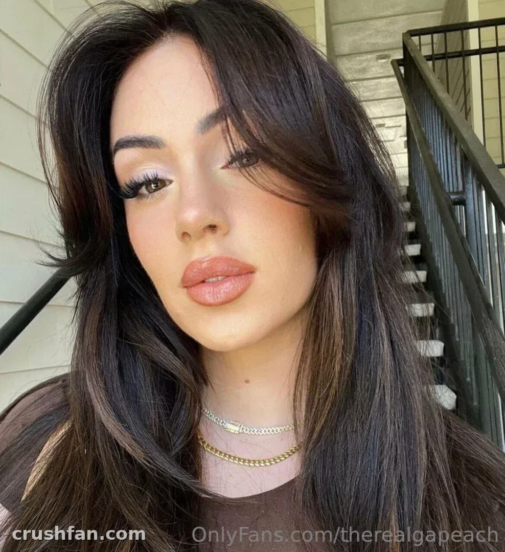 Hayley Davis en un retrato en primer plano al aire libre con cabello largo y oscuro y un top marrón