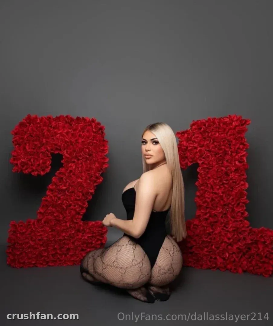 214 Dallas Slayer crouching in a black bodysuit and fishnets beside large red rose numbers.