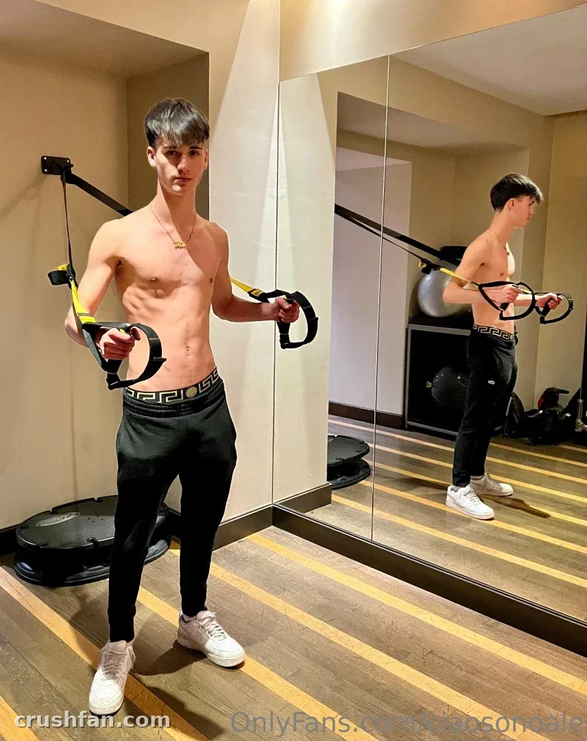 Alex hält Widerstandsbänder in einem verspiegelten Home-Gym mit gestreiftem Holzboden