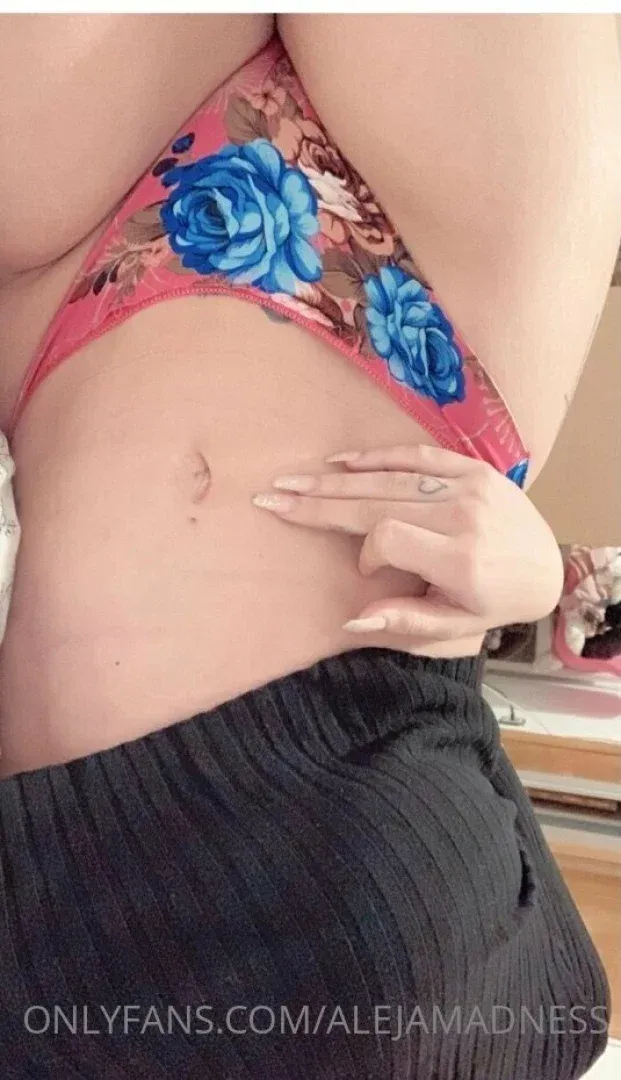 Gros plan d'une femme en lingerie florale rose avec une main sur la taille.