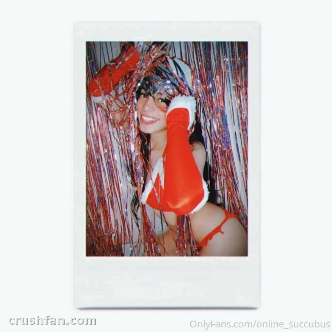 Creator smiling among red and silver tinsel inside a white polaroid frame