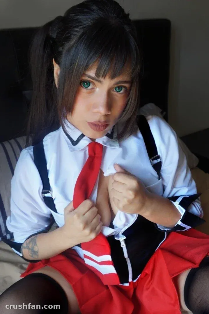 Kinoko Rin dans une tenue de cosplay blanche et rouge assise en intérieur