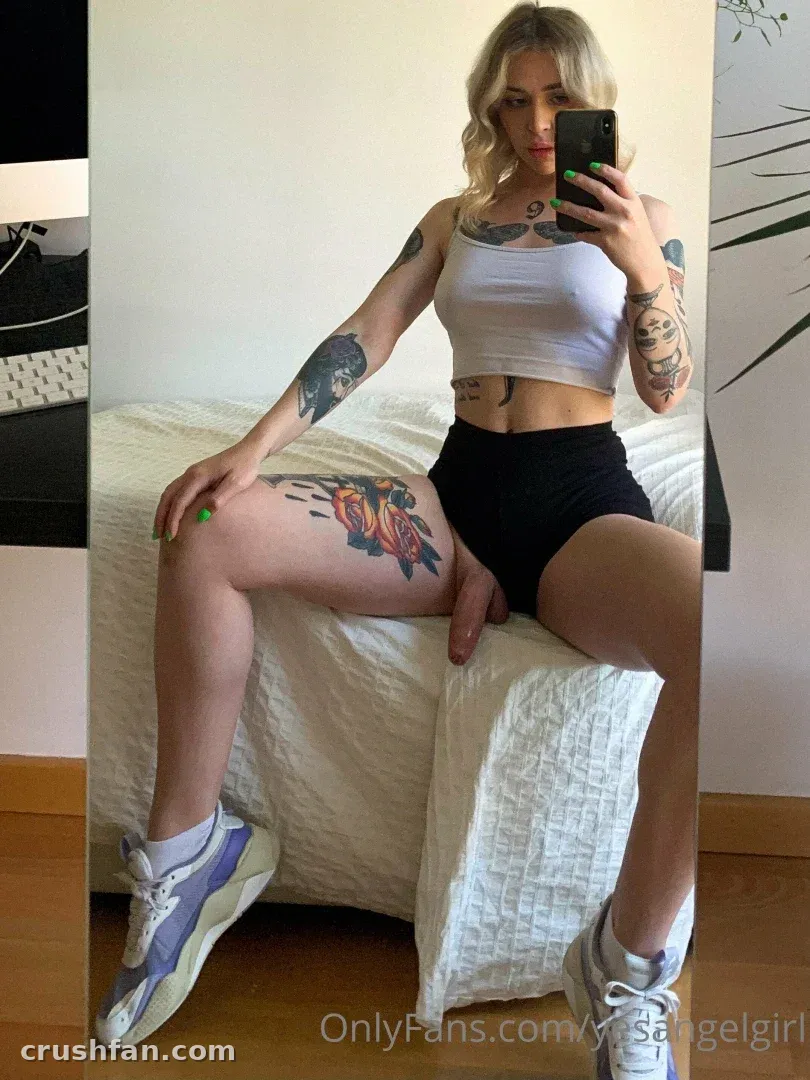 Creator in einem weißen Crop-Top und schwarzer Shorts beim Spiegel-Selfie in Innenräumen