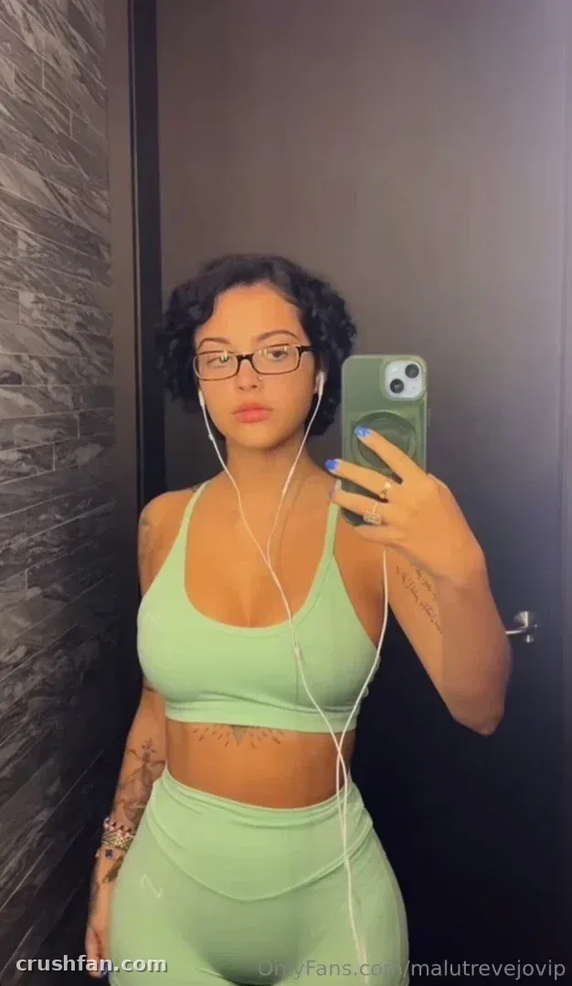 Malu Trevejo com um conjunto de duas peças verde-claro tirando uma selfie no espelho em ambiente interno