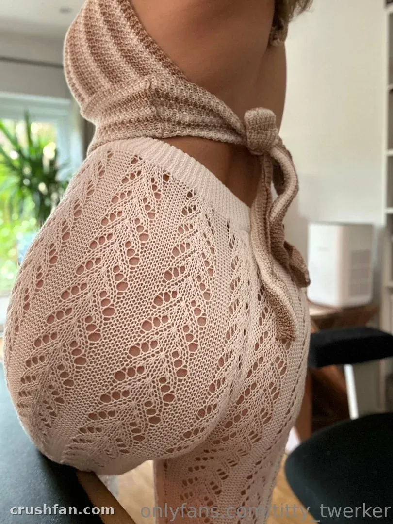 Tamara in a cream crochet outfit standing indoors with a plant in the background.