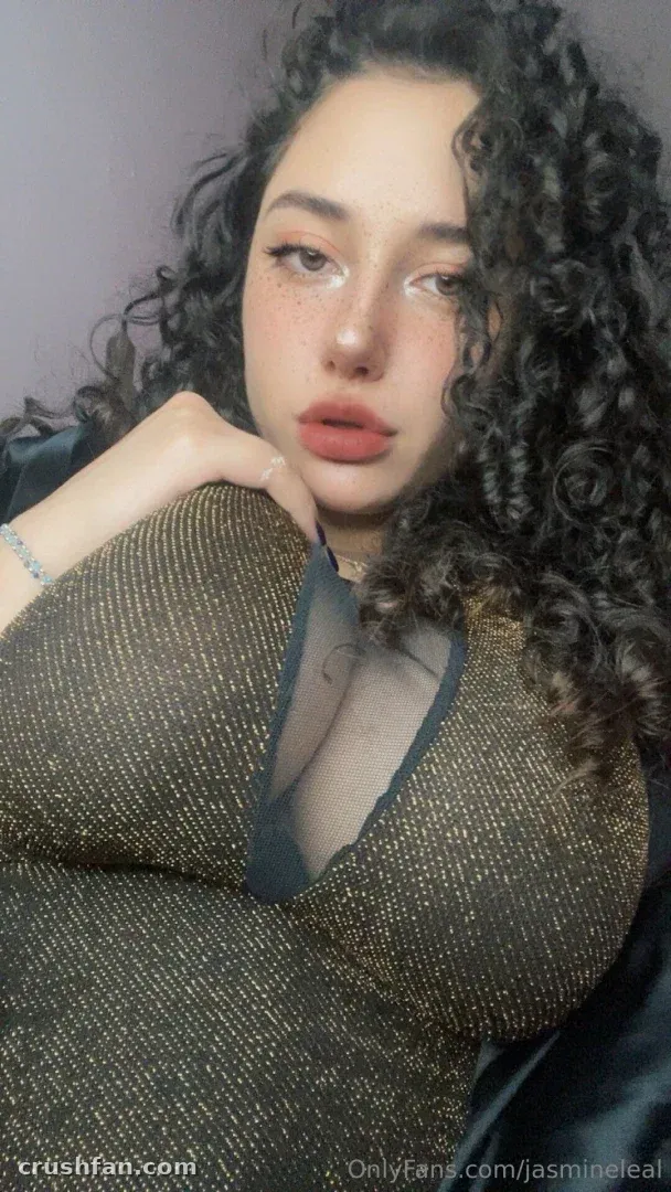 Jasmine Leal in einem schimmernden Strickoberteil, lockiges Haar, weiche Studiobeleuchtung
