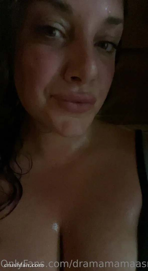 Nahaufnahme-Low-Light-Selfie von DMA mit dunklem Haar und einem schwarzen Träger an ihrer Schulter