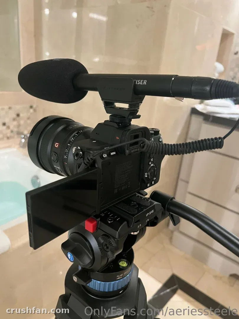 Cámara sobre un trípode con un micrófono en un entorno de baño